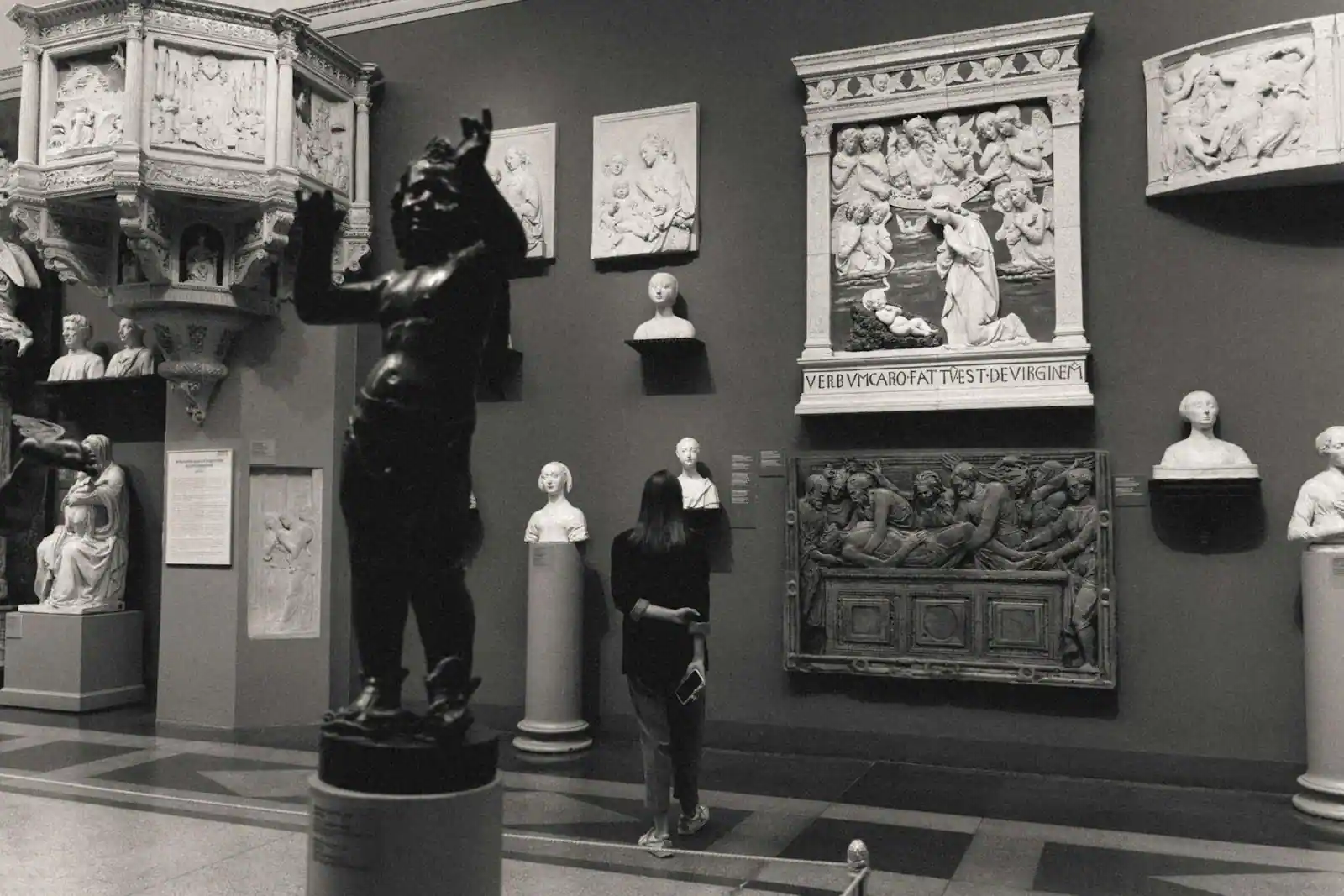 Salle de musée avec visiteurs devant des œuvres exposées dans une atmosphère feutrée