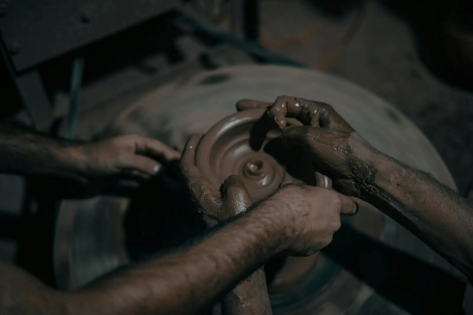 Atelier de céramique avec roues de potier et étagères de poteries séchant dans un espace artisanal