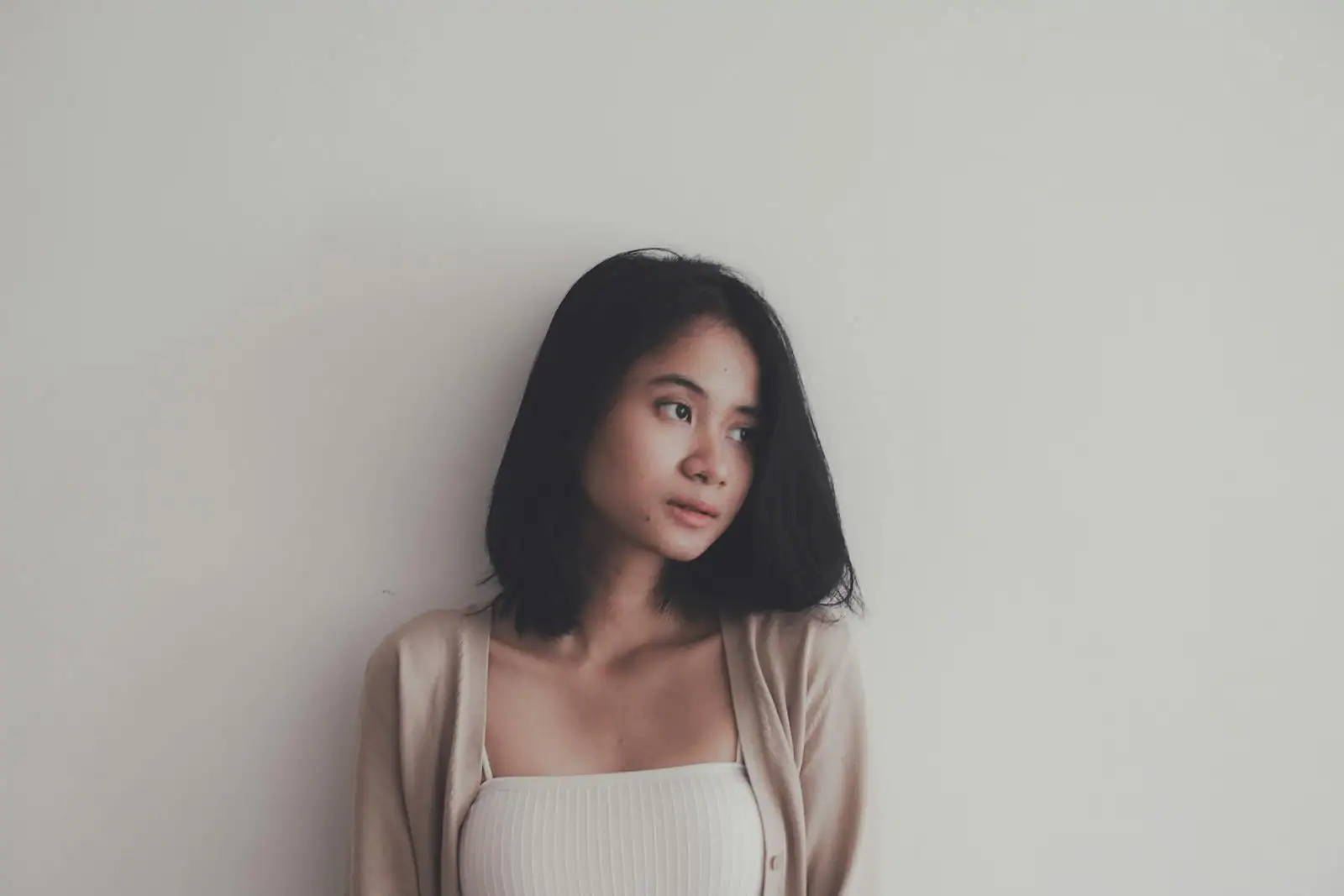 Femme de profil avec cheveux mi-longs ondulés, lumière naturelle, ambiance éditoriale