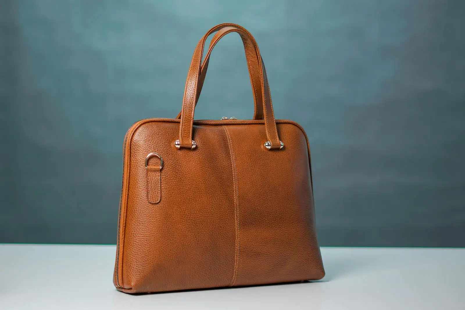 Sac à main en cuir posé sur une table claire, lumière douce mettant en valeur le grain et les coutures