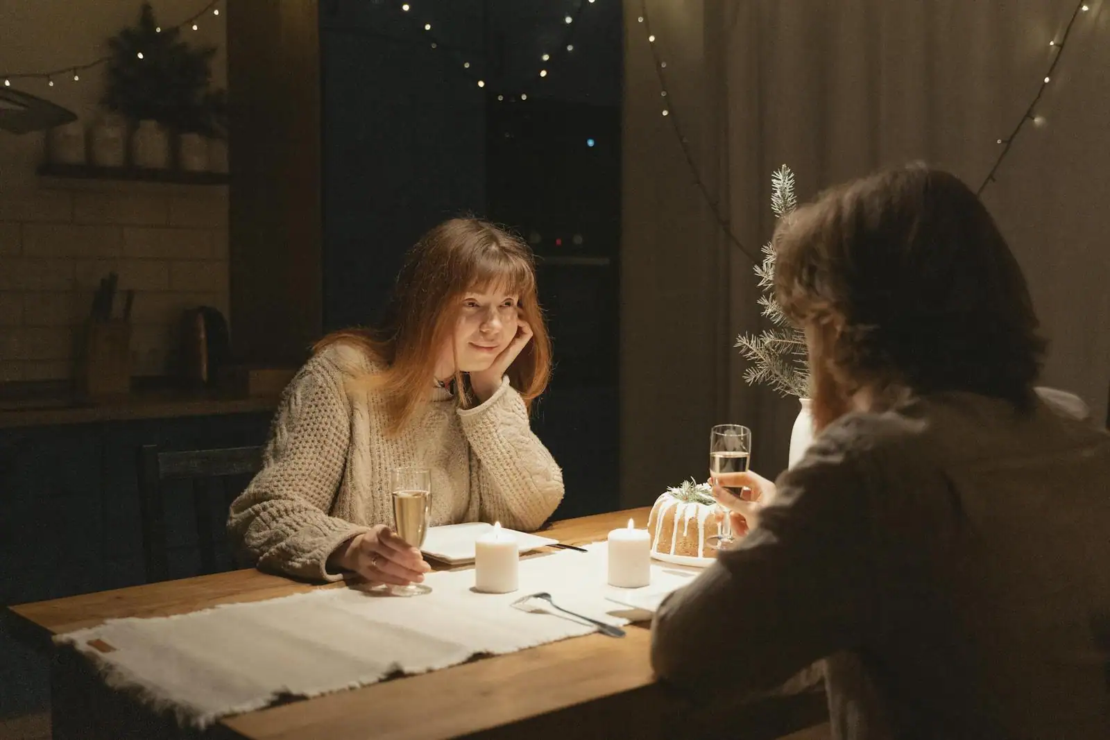 Couple en conversation feutrée dans un café à lumière tamisée, regards croisés, ambiance suspendue