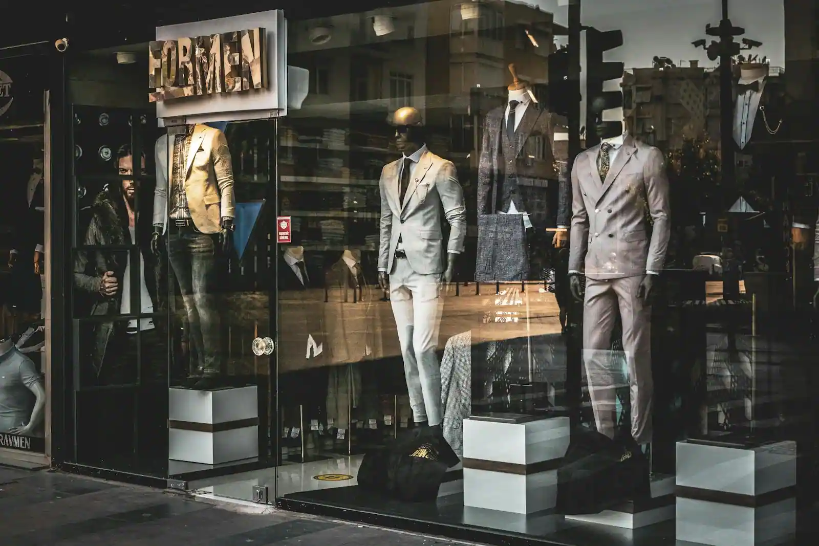 Vitrine de boutique de costumes haut de gamme à Paris, ambiance éditoriale, lumière du soir
