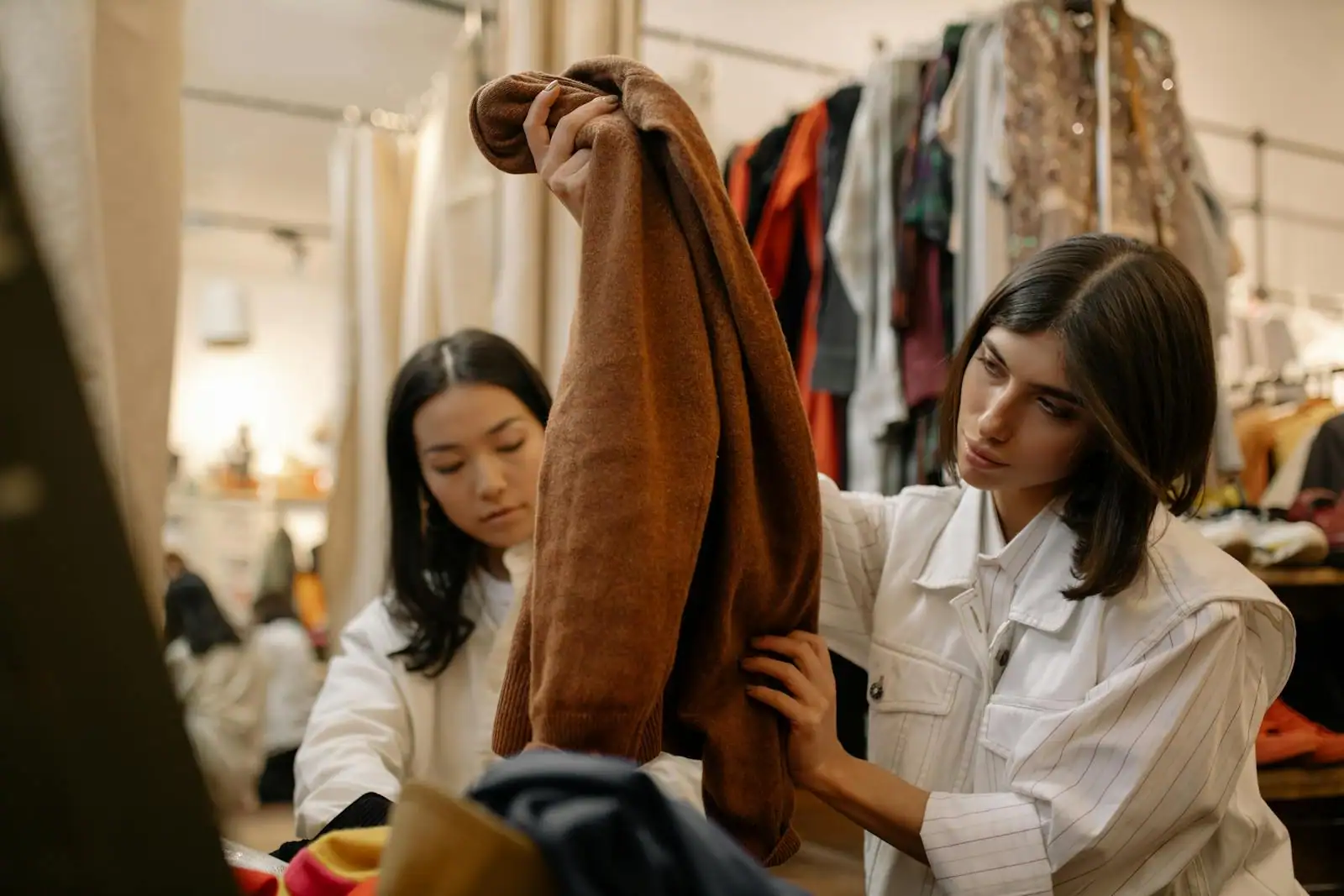 Portant de vêtements féminins dans une boutique de seconde main avec étiquettes prix visibles