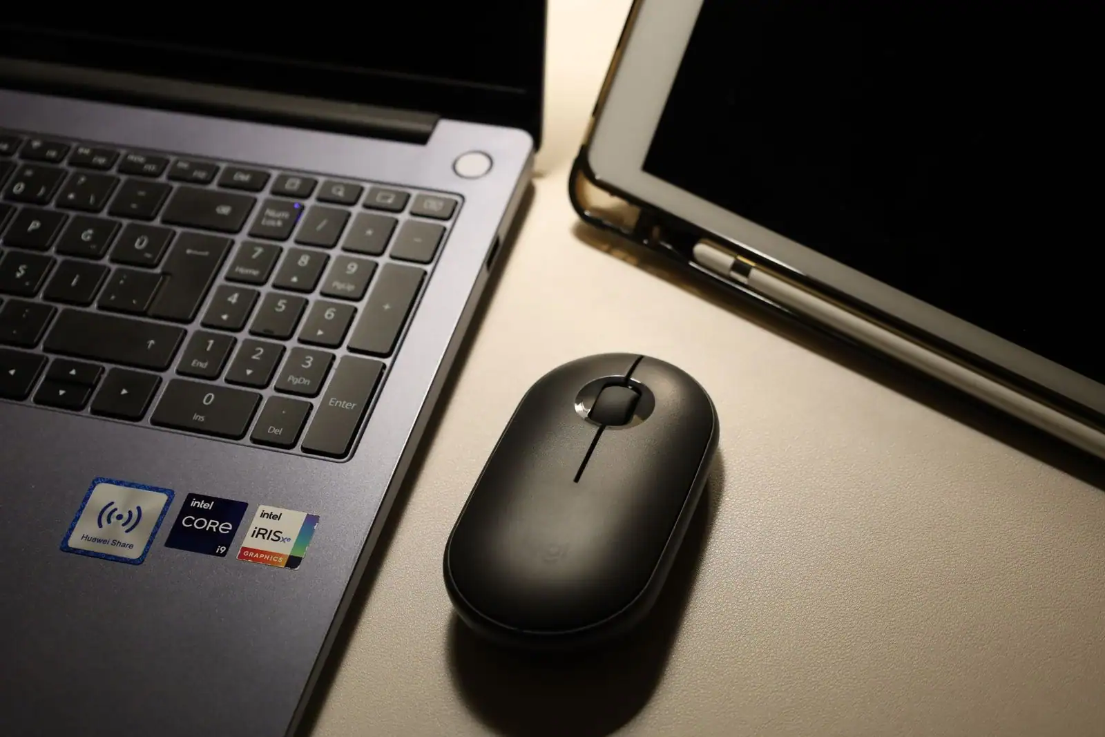 Ordinateur portable, souris sans fil et tablette avec stylet posés côte à côte sur un bureau