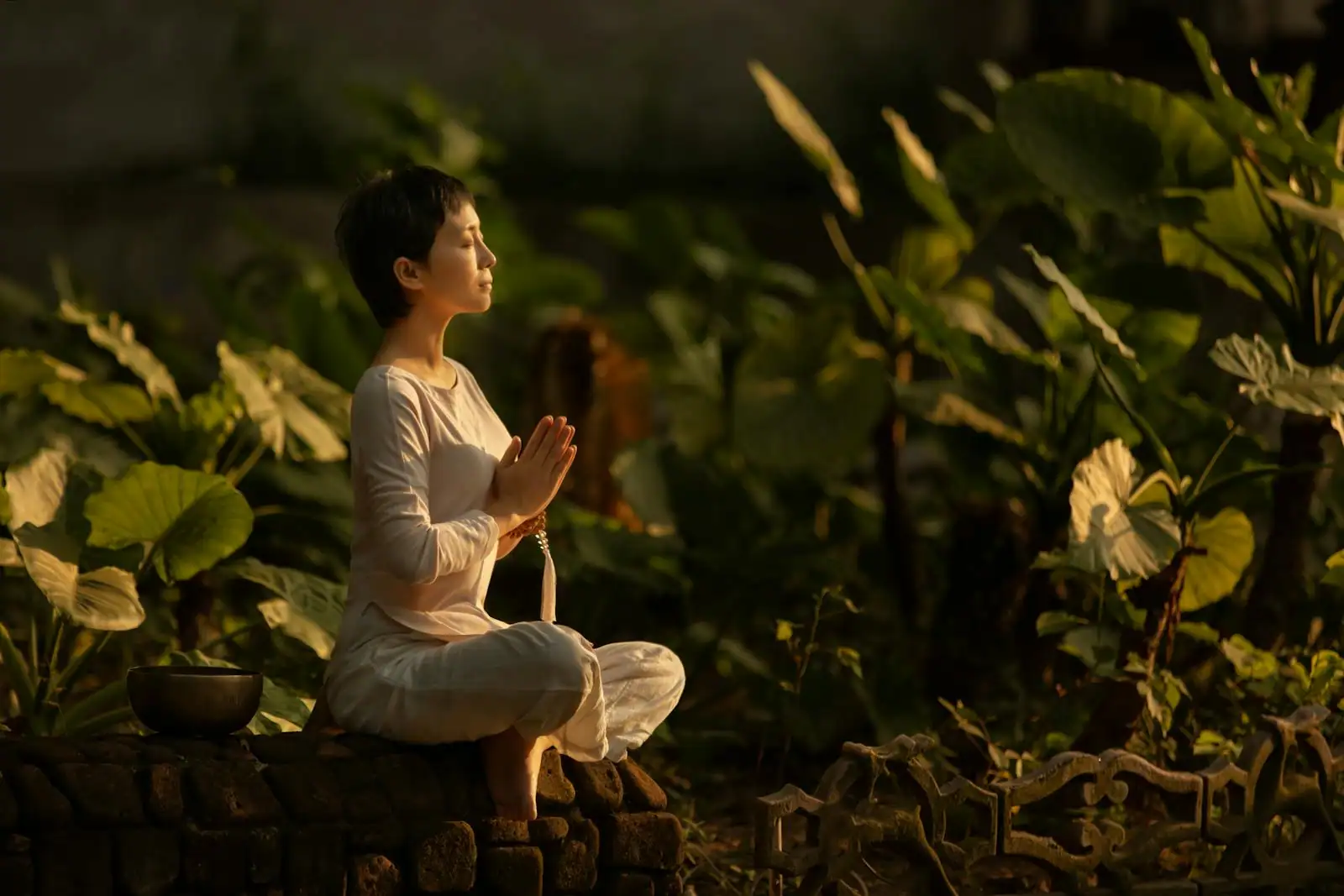 Femme assise en méditation paisible dans une lumière naturelle douce, symbole de quête intérieure