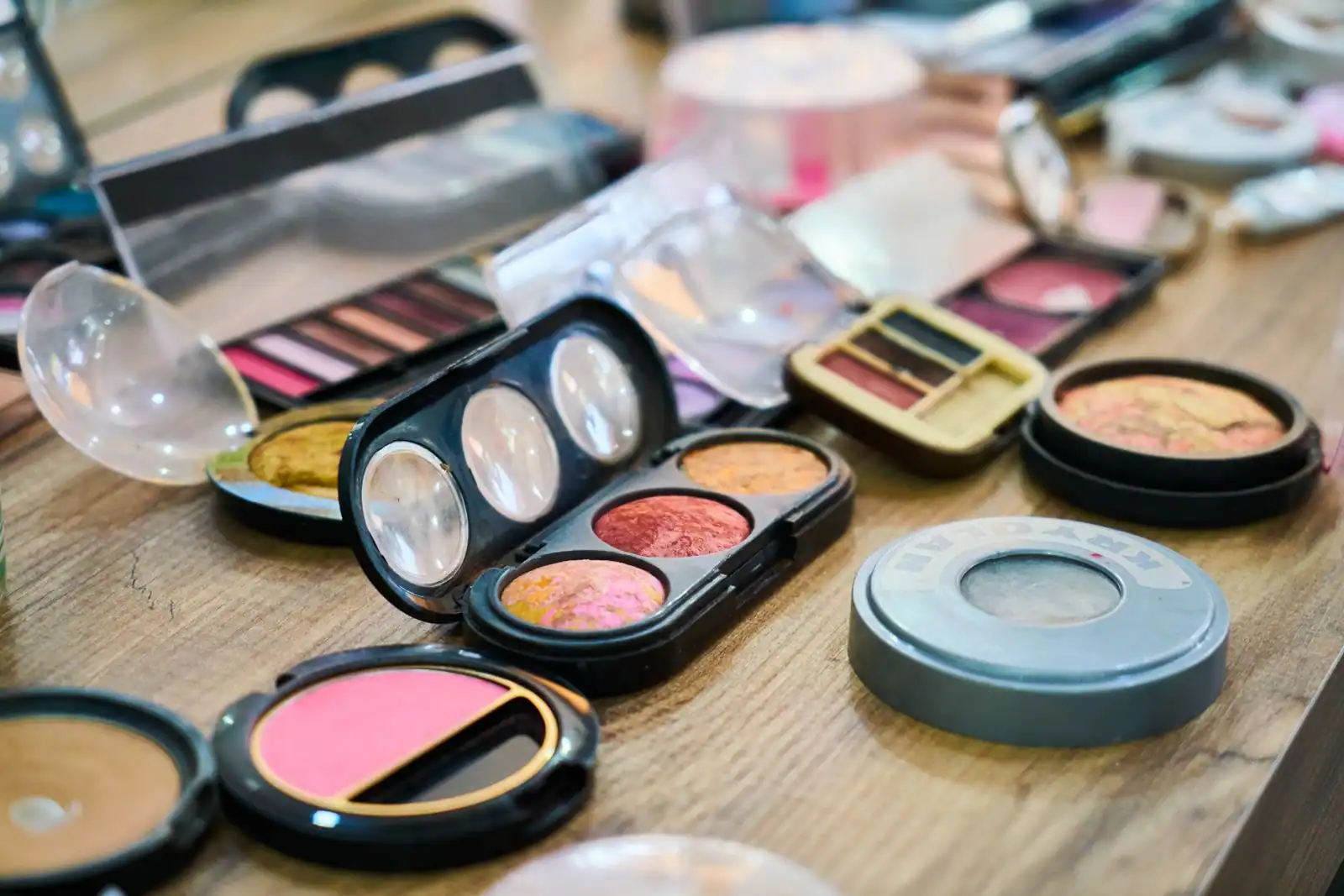Palettes et produits de maquillage colorés posés sur une table en bois