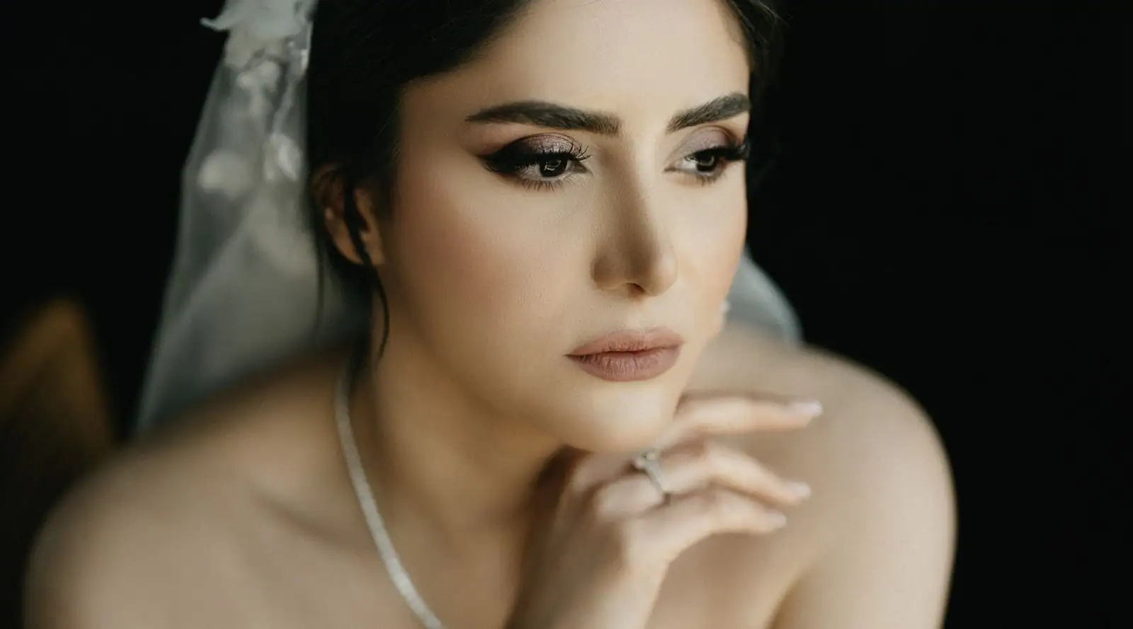 Mariée au maquillage naturel et au voile, teint lumineux et regard adouci.