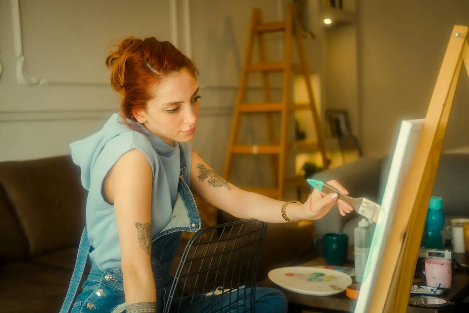 Femme peignant sur une toile dans un atelier lumineux, absorbée par son loisir créatif