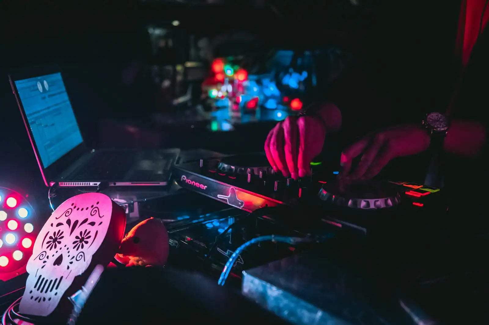 DJ aux platines lors d'une soirée de mariage, piste de danse éclairée par des jeux de lumière