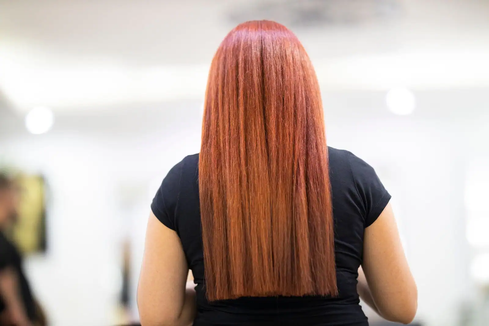 Femme de dos aux longs cheveux lisses, raides et brillants tombant droit dans le dos