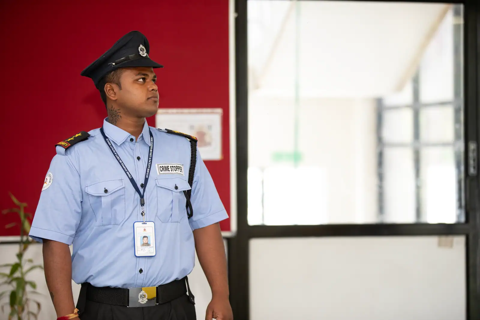 Un agent de sécurité en uniforme, à l'entrée d'un bâtiment, illustrant le vêtement professionnel.